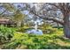 Scenic pond view featuring a fountain and mature trees casting shadows on green grass at 3183 Windrush Bourne # 42, Sarasota, FL 34235