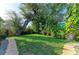 This grassy backyard features mature trees and stone pathways at 405 Magellan Dr, Sarasota, FL 34243