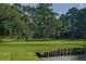 Scenic golf course view featuring mature trees, lush green fairways, and a calm waterfront at 405 Magellan Dr, Sarasota, FL 34243