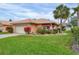 Charming home boasts a well-manicured lawn, mature landscaping, and a cheerful peach exterior at 4302 Turnberry Ct, Bradenton, FL 34210