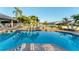Community pool with chairs surrounded by palm trees and view of the neighborhood at 4302 Turnberry Ct, Bradenton, FL 34210