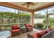 Covered patio with outdoor furniture surrounded by green trees and an open space at 4302 Turnberry Ct, Bradenton, FL 34210