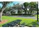 Outdoor recreational area with a basketball court and picnic tables under the shade of mature trees at 4656 72Nd E Ct, Bradenton, FL 34203