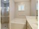 Well-lit bathroom featuring a walk-in shower, a soaking tub, and a neutral color scheme at 4656 72Nd E Ct, Bradenton, FL 34203