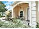 Inviting front porch with tiled floor, comfortable seating, arched entryway, and lovely landscaping at 4656 72Nd E Ct, Bradenton, FL 34203