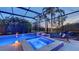 Beautiful screened pool and spa area with calming landscape views at twilight at 4718 Claremont Park Dr, Bradenton, FL 34211