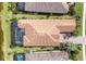 Aerial view of a tile-roofed single-Gathering home with a screened-in pool and lush landscaping at 4719 Cabreo Ct, Bradenton, FL 34211