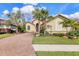 Charming home with a brick driveway, a well-manicured lawn, and mature landscaping, including palm trees at 4719 Cabreo Ct, Bradenton, FL 34211