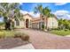 Attractive home featuring a brick driveway, manicured lawn, lush landscaping, and a two-car garage at 4719 Cabreo Ct, Bradenton, FL 34211
