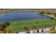 Picturesque golf practice area with golf carts, waterfront view, and well-maintained lush lawn at 4719 Cabreo Ct, Bradenton, FL 34211