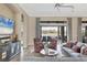 Open-concept living room featuring cozy seating, tile floors, large windows, and scenic lake views at 4719 Cabreo Ct, Bradenton, FL 34211