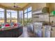 Outdoor kitchen in screened-in lanai, featuring a grill, sink, mini fridge, and lake views at 4719 Cabreo Ct, Bradenton, FL 34211