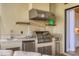 Outdoor kitchen with a stainless steel grill, granite countertops, and a mini fridge, ideal for entertaining at 4719 Cabreo Ct, Bradenton, FL 34211