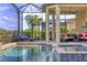 Luxurious screened-in pool area with a waterfall feature, sun loungers, and lush landscaping at 4719 Cabreo Ct, Bradenton, FL 34211