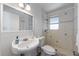 Bathroom showcasing a white vanity sink and a tiled walk-in shower with a window at 520 Spring Ave # A, Anna Maria, FL 34216