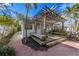 Outdoor deck with a wooden pergola, seating area, and landscaped surroundings at 520 Spring Ave # A, Anna Maria, FL 34216