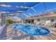 A screened-in pool featuring a unique kidney shape and sunbathing chairs at 5616 Garden Lakes Majestic, Bradenton, FL 34203