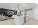 Open-concept living room featuring a large island with a sink, modern light fixtures, tile flooring, and sliding doors to the balcony at 5628 Summit Point Cir # 103, Bradenton, FL 34210