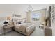 Bright bedroom with neutral décor, featuring a patterned bedspread and modern lighting fixtures by the window at 5628 Summit Point Cir # 103, Bradenton, FL 34210