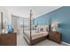 Comfortable bedroom featuring a stylish bed with a blue accent wall, lamps, and a window at 5628 Summit Point Cir # 103, Bradenton, FL 34210
