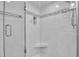 Close-up of a renovated tiled shower with glass door and built-in niche at 6608 13Th Avenue W Dr, Bradenton, FL 34209