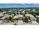 An aerial shot displays a beige two-story home by a pond within a leafy, vibrant community at 6961 Scrub Jay Dr, Sarasota, FL 34241