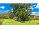 This backyard view features a lush lawn and a screened lanai overlooking the serene lake at 6961 Scrub Jay Dr, Sarasota, FL 34241
