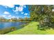 Scenic backyard view features a serene lake and meticulously maintained lawn at 6961 Scrub Jay Dr, Sarasota, FL 34241