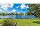 Beautiful backyard view of a lake surrounded by lush greenery and blue skies at 6961 Scrub Jay Dr, Sarasota, FL 34241
