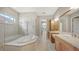 A spacious bathroom with a soaking tub and separate shower, plus dual sinks with wood cabinets at 6961 Scrub Jay Dr, Sarasota, FL 34241