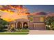 Stunning two-story stucco home featuring a tile roof, arched entryway, and lush landscaping against a vibrant sunset backdrop at 6961 Scrub Jay Dr, Sarasota, FL 34241