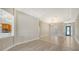 Bright living room with tile and wood floors, tray ceiling, and open layout leading to the kitchen and entryway at 6961 Scrub Jay Dr, Sarasota, FL 34241