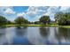 Picturesque view of a calm pond reflecting houses and a blue sky with white fluffy clouds at 6961 Scrub Jay Dr, Sarasota, FL 34241