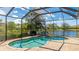 Inviting screened-in pool area overlooking a peaceful lake, surrounded by lush landscaping at 6961 Scrub Jay Dr, Sarasota, FL 34241