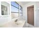 Bathroom featuring a tiled shower, vanity, decorative mirror, and window at 7 High St, Bradenton, FL 34208