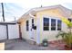 Charming yellow home featuring a new front door, tropical plants, and an inviting brick patio at 7 High St, Bradenton, FL 34208