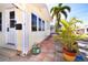 Charming yellow home featuring lush landscaping with a tile patio and tropical palm tree at 7 High St, Bradenton, FL 34208