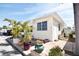 Charming yellow home featuring lush landscaping with a tile patio, door, and a white carport at 7 High St, Bradenton, FL 34208