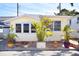 Charming yellow home with white trim surrounded by tropical plants and a brick patio at 7 High St, Bradenton, FL 34208