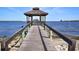 Waterfront property featuring a long pier leading to a charming gazebo overlooking the scenic bay and skyline at 7 High St, Bradenton, FL 34208