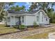 Quaint home with light gray siding, dark gray trim, and a welcoming front entrance with new landscaping at 720 26Th W St, Bradenton, FL 34205