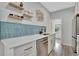 Modern kitchenette featuring floating shelves, stylish backsplash, and stainless steel dishwasher at 720 26Th W St, Bradenton, FL 34205