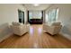 Bright living room with a brown couch and two white chairs with hardwood floors and sliding glass doors at 7433 N Leewynn Dr, Sarasota, FL 34240