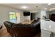 Living room with a large brown couch and a view of the backyard through sliding glass doors at 7433 N Leewynn Dr, Sarasota, FL 34240