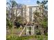 Luxury apartment building visible through a serene wooded area and decorative arch at 750 N Tamiami Trl # 407, Sarasota, FL 34236