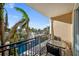 Outdoor patio with black metal railings, two chairs, and a table overlooking palm trees and water fountain at 750 N Tamiami Trl # 407, Sarasota, FL 34236