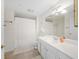 Bright bathroom featuring a white vanity, large mirror, and shower with neutral-colored curtain at 750 N Tamiami Trl # 407, Sarasota, FL 34236