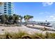 Serene beachfront with lounge chairs, offering stunning water views and relaxation at 750 N Tamiami Trl # 407, Sarasota, FL 34236