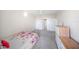 Cozy bedroom featuring a floral bedspread, grey carpeting, dresser, and ensuite bathroom at 750 N Tamiami Trl # 407, Sarasota, FL 34236