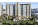 Exterior shot of high-rise building with lush landscaping and water features at 750 N Tamiami Trl # 407, Sarasota, FL 34236